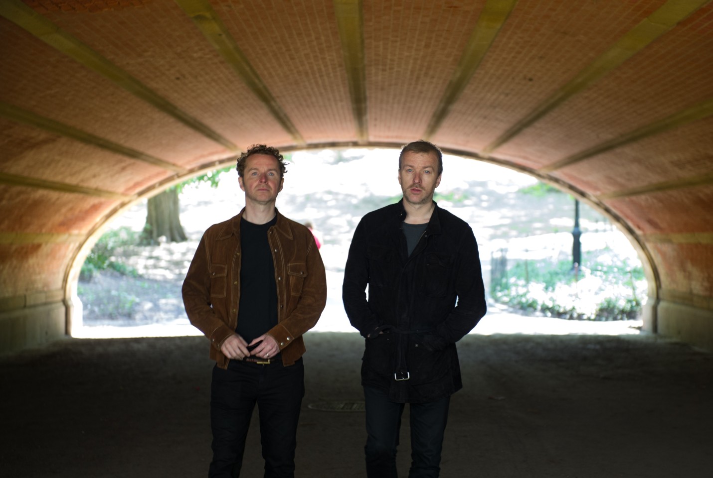 two men standing in a tunnel